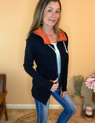 Black sweatshirt with bright orange accents and thumbholes