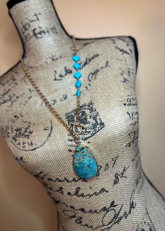 Close-up shot of the turquoise pendant and diamond-shaped details